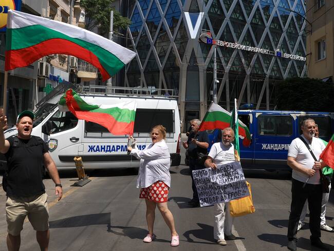 Sofia (Bulgaria), 08/07/2025.- People wave national flags during a protest against the adoption of the Euro, in front of the European Parliament building in Sofia, Bulgaria, 08 July 2025. The European Parliament and, following a decision by the Economic and Financial Affairs Council in Brussels, will make the final decisions that will determine whether Bulgaria will join the Eurozone. (Protestas, Bruselas) EFE/EPA/VASSIL DONEV