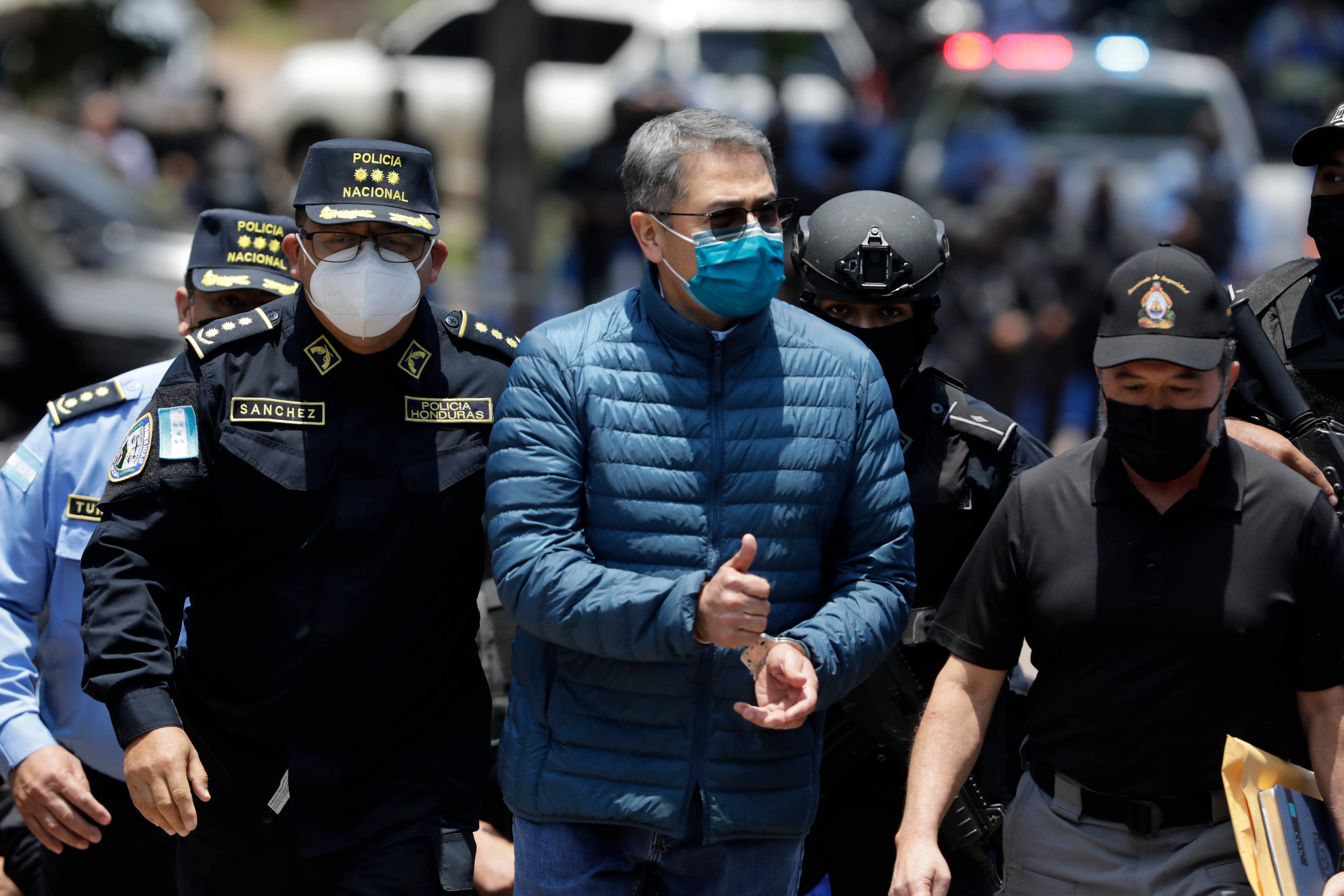 TEGUCIGALPA, HONDURAS - APRIL 21: Former President of Honduras Juan Orlando Hernandez is escorted by Members of the Police Special Forces to be extradited to U.S.to face charges of taking bribes from drug traffickers at Honduran National Directorate of Special Forces on April 21, 2022 in Tegucigalpa, Honduras. Hernandez will stand trial for allegedly aiding the smuggling of hundreds of tons of cocaine to America (Photo by Jorge Cabrera/Getty Images)