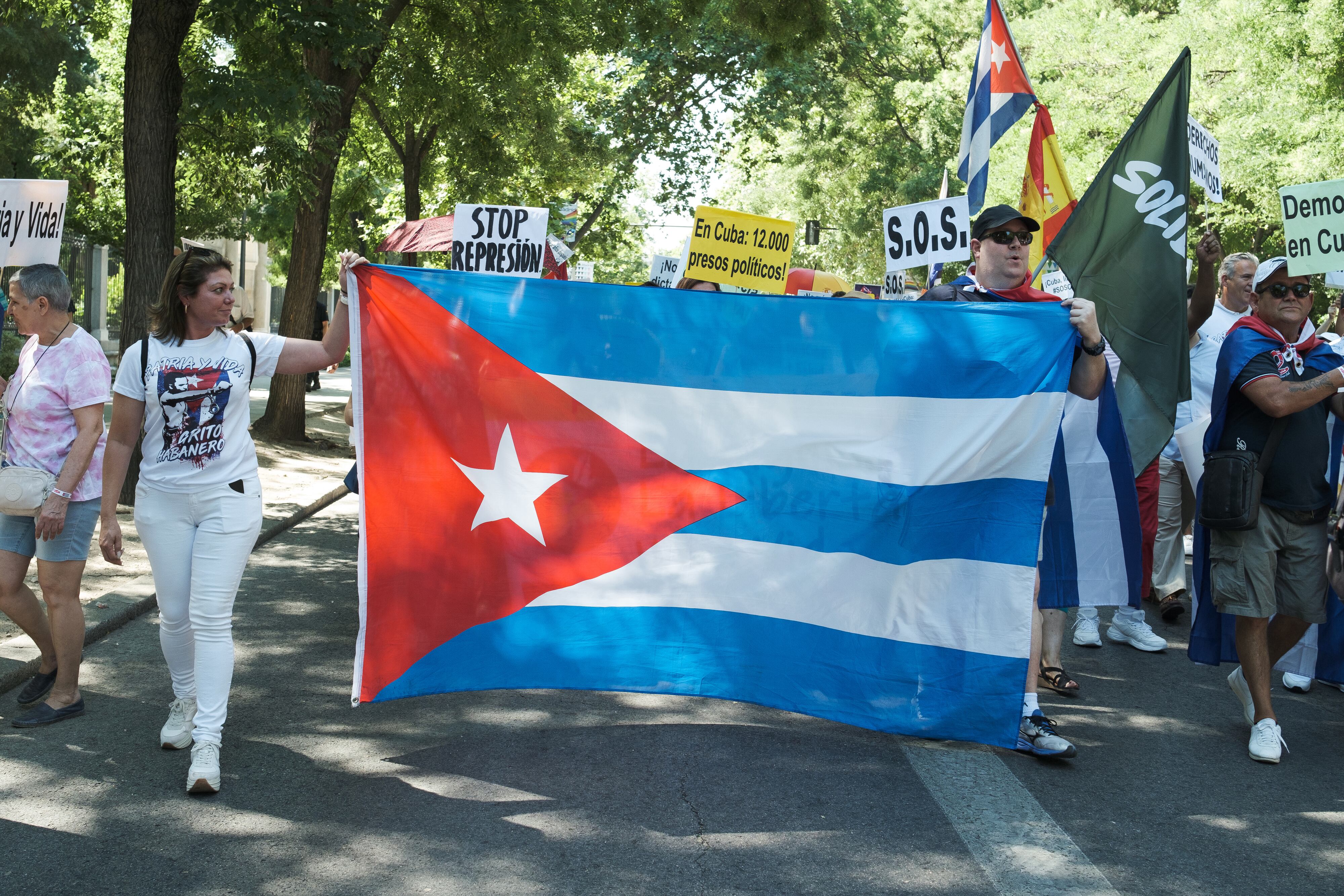 MADRID, SPAIN - 2022/07/10: Protesters march while holding a Cuban flag during the demonstration to demand the end of the dictatorship and the freedom of political prisoners in Cuba held on the Paseo de Prado in Madrid. The march is organised by #SOSCUBA to commemorate July 11 and demand the end of the dictatorship in Cuba. (Photo by Atilano Garcia/SOPA Images/LightRocket via Getty Images)