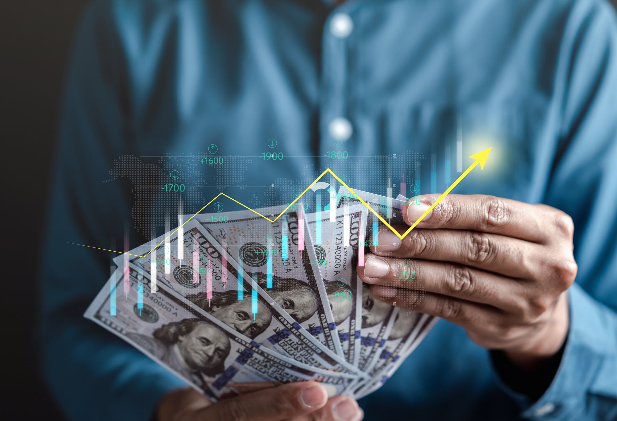 Hombre de negocios contando dólares mientras se refleja gráfica sobre los aumentos de la divisa (Getty Images)