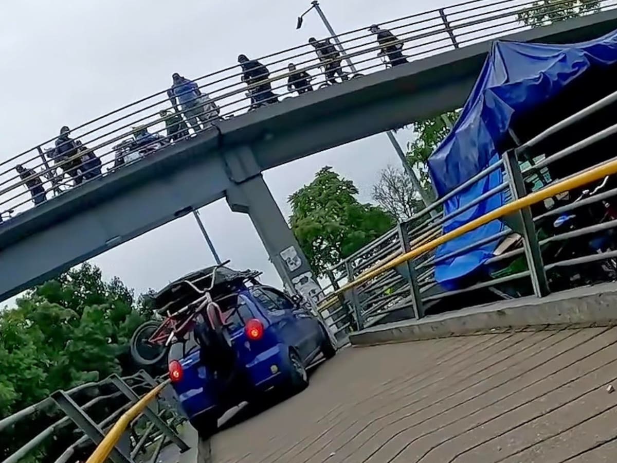 Autoridades buscan a influencers que intentaron subir un carro a un puente peatonal en la calle 26