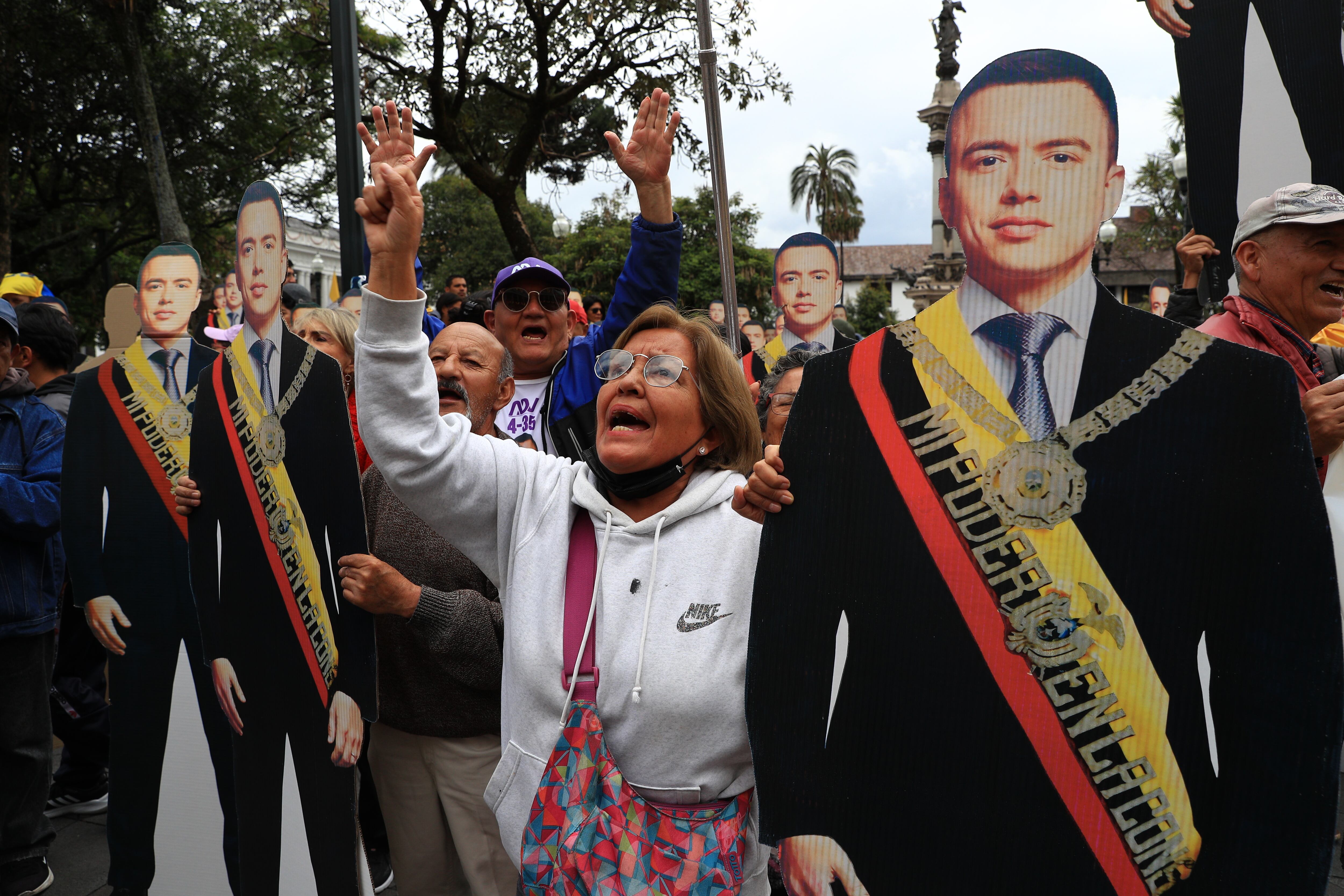 AME8774. QUITO (ECUADOR), 05/01/2025.- Una simpatizante del presidente de Ecuador, Daniel Noboa, gritan consignas junto a figuras con la imagen de Noboa este domingo, afuera del Palacio de Gobierno en Quito (Ecuador). La campaña electoral para los comicios generales de febrero en Ecuador inicia en medio de una encrucijada en torno a la sucesión presidencial, que reclama la vicepresidenta electa en las urnas, Verónica Abad, quien no acató la disposición del gobernante, Daniel Noboa, de presentarse hasta el pasado 27 de diciembre, en calidad de consejera temporal, en la embajada de Ankara. EFE/ José Jácome