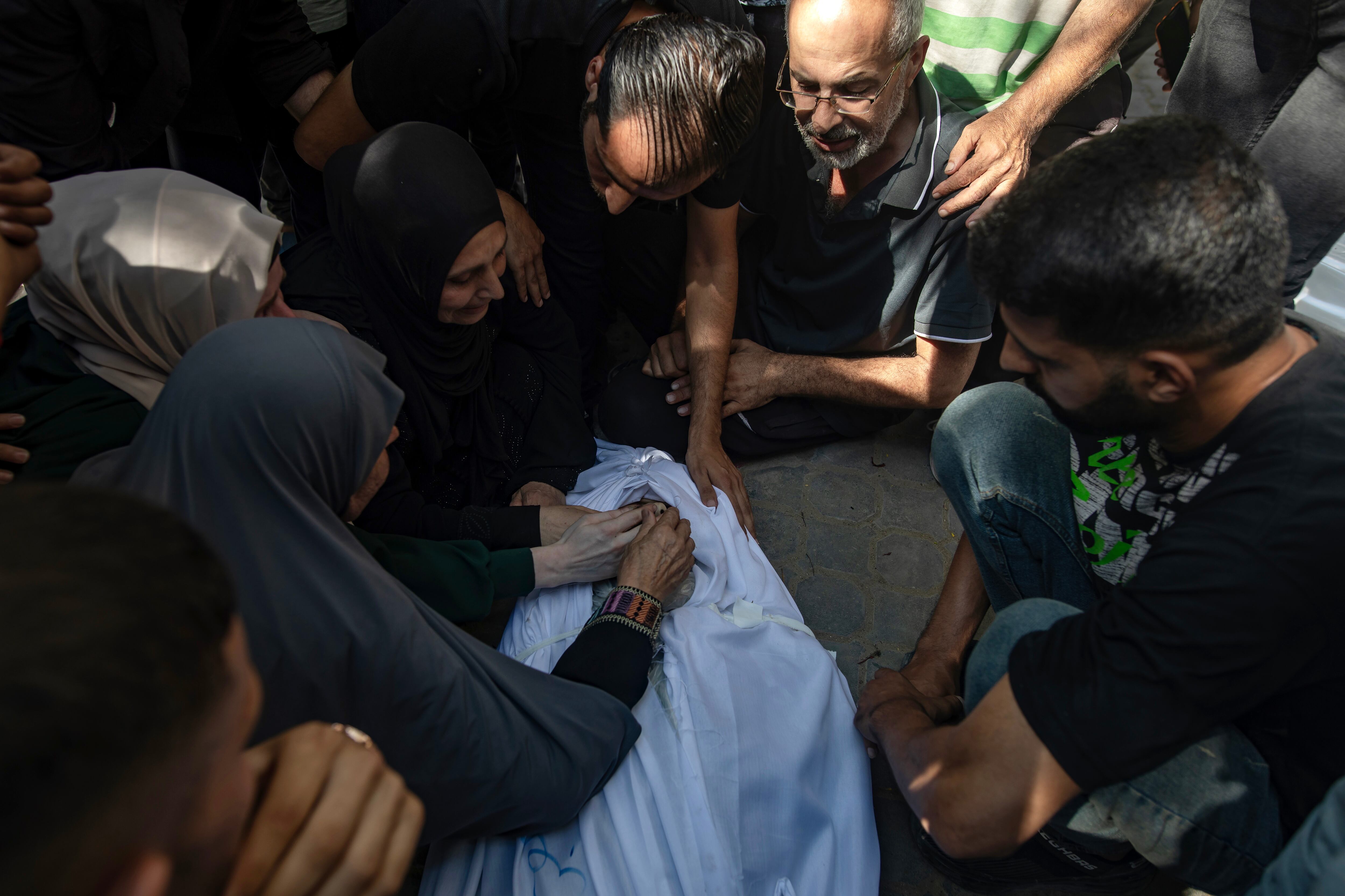 Familiares del periodista Ismail Abu Hatab lloran junto a su cuerpo luego de que fuese asesinado por un bombardeo israelí en el hospital de Al-Shifa. 
EFE/EPA/HAITHAM IMAD
