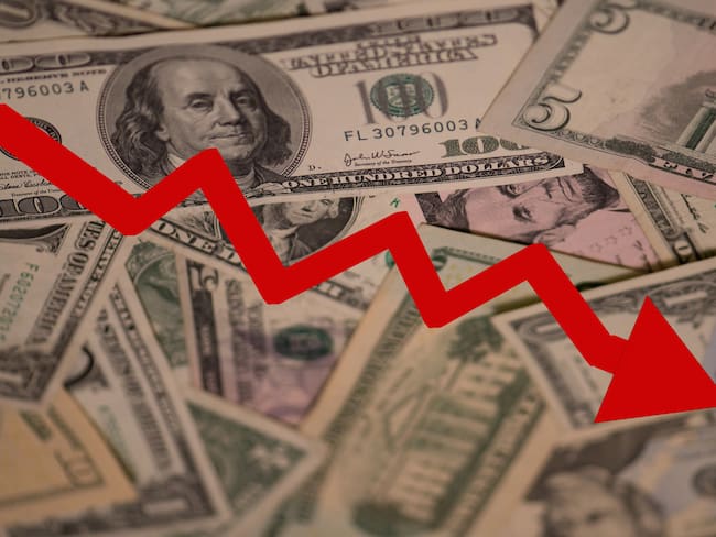 Dólares con gráfica a la baja (Getty Images)