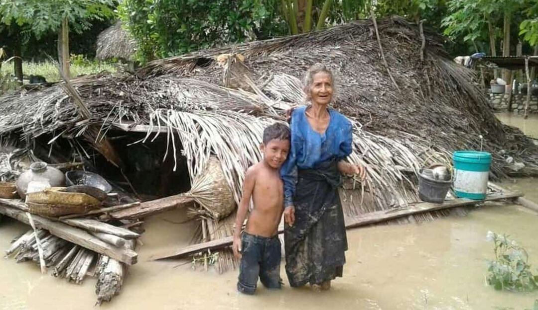 Una mujer y su nieto junto a su casa destruida por las inundaciones que han afectado a Indonesia.