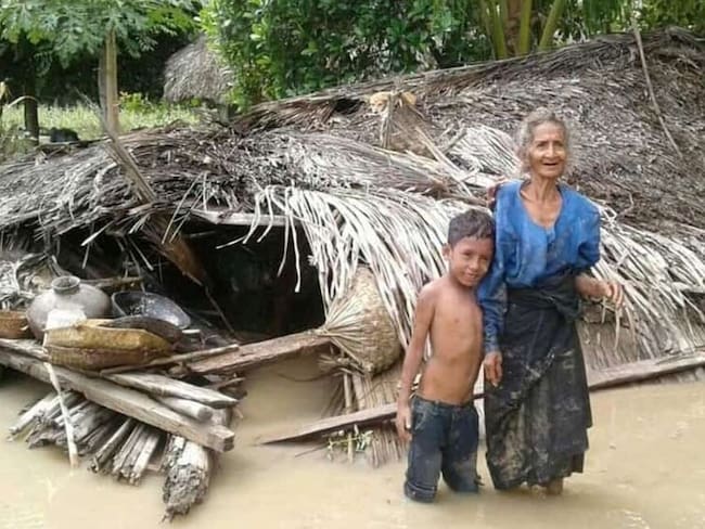 Una mujer y su nieto junto a su casa destruida por las inundaciones que han afectado a Indonesia.