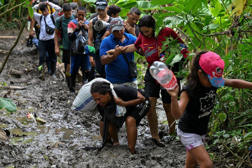 TOPSHOT - Venezuelan migrants arrive at Canaan Membrillo village, the first border control of the Darien Province in Panama, on October 13, 2022. - The clandestine journey through the Darien Gap usually lasts five or six days at the mercy of all kinds of bad weather: snakes, swamps and drug traffickers who use these routes to take cocaine to Central America. - TO GO WITH AFP STORY BY JUAN JOSE RODRIGUEZ (Photo by Luis ACOSTA / AFP) / TO GO WITH AFP STORY BY JUAN JOSE RODRIGUEZ (Photo by LUIS ACOSTA/AFP via Getty Images)