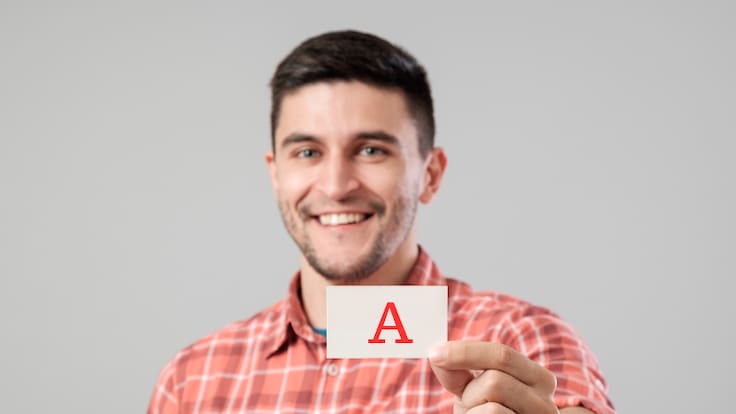Hombre mostrando la letra A en un papel (Fotos vía Getty Images)