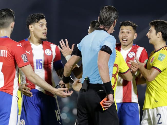 Los jugadores de Colombia le protestan al árbitro Raphael Claus.