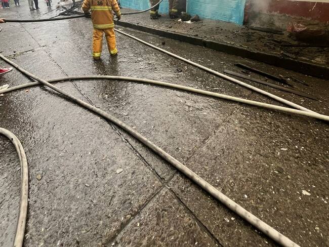 Los bomberos intentando sofocar el fuego en las viviendas afectadas. Foto: Unidad de Gestión del Riesgo de Manizales.