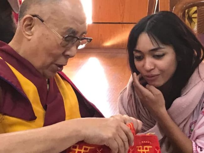 Tania regala al Dalai Lama una mochila de su región.