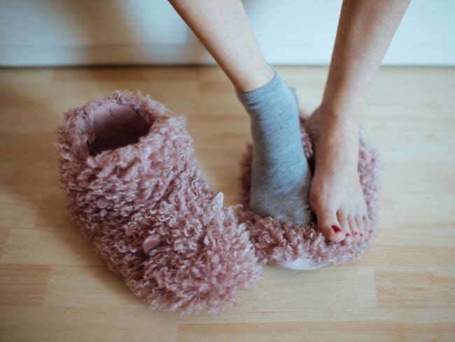 Mujer poniéndose medias por el frío en sus pies (Getty Images)