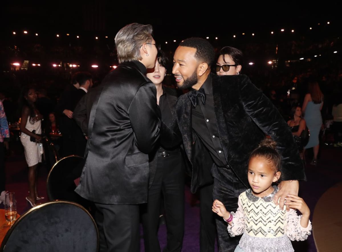 Suga y Jimin saludando a John Legend. 