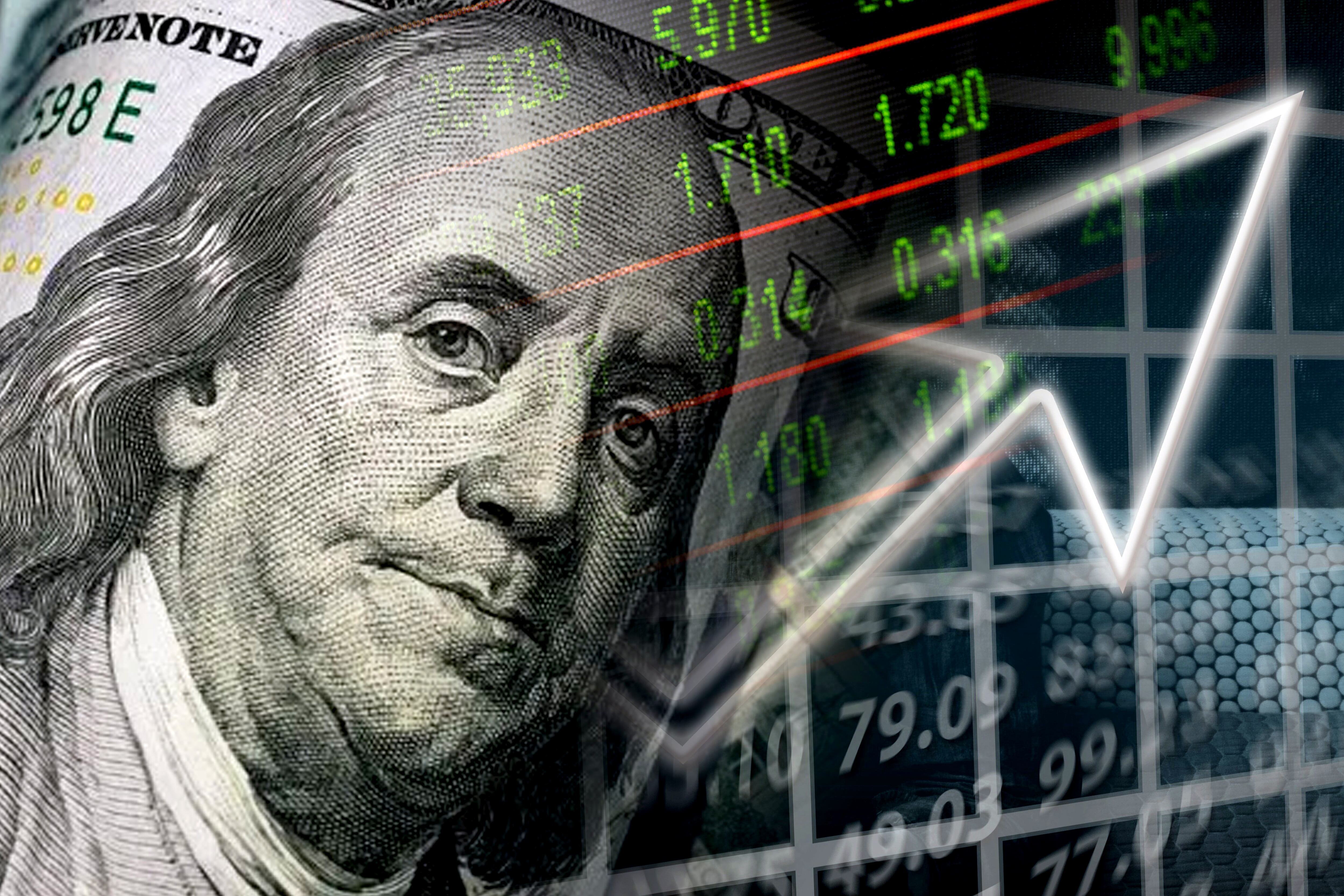 Billete de 100 dólares con una gráfica e indicadores económicos (Foto vía GettyImages)