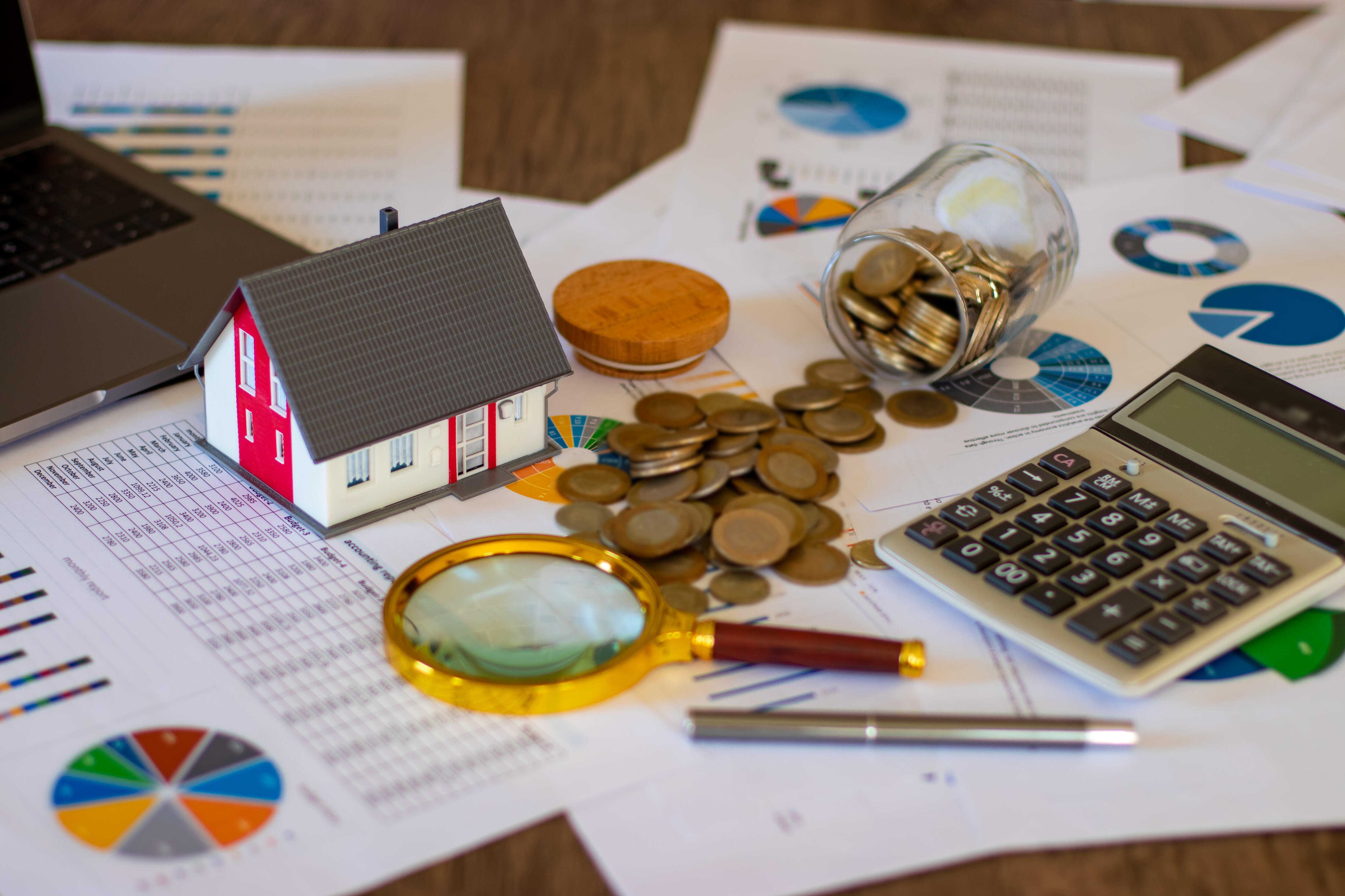 Figura de casa junto a monedas, lupa y calculadora. (Foto: Getty Images)