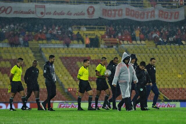 El árbitro del partido y los delegados de ambos equipos hacen una revisión sobre el campo de El Campín / Colprensa.