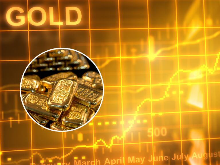 Lingotes de oro con un gráfico de fluctuación de cifras al fondo (Fotos vía Getty Images)