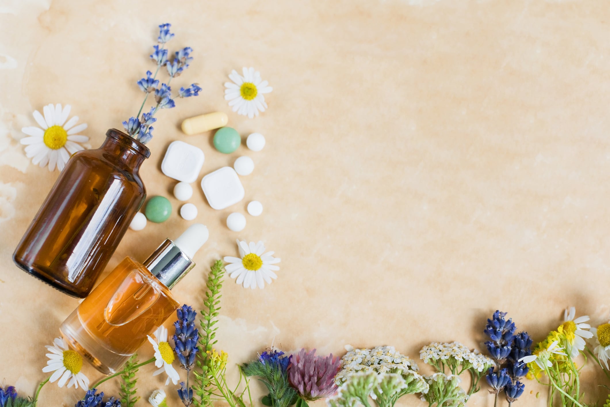 Wildflowers, vintage brown bottles and pills on a vintage parchment paper, copy space. Naturopathy mockup