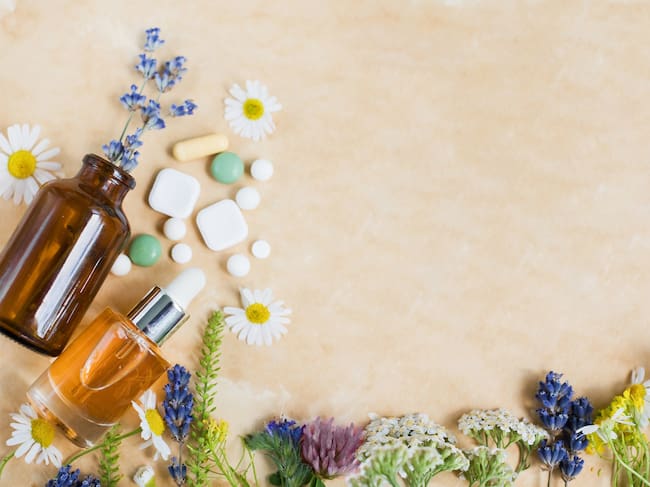 Wildflowers, vintage brown bottles and pills on a vintage parchment paper, copy space. Naturopathy mockup