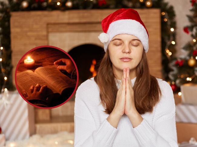 Mujer concentrada con gorro de Navidad sentada cerca de la chimenea y el árbol de Navidad rezando // biblia y una vela // Getty Images