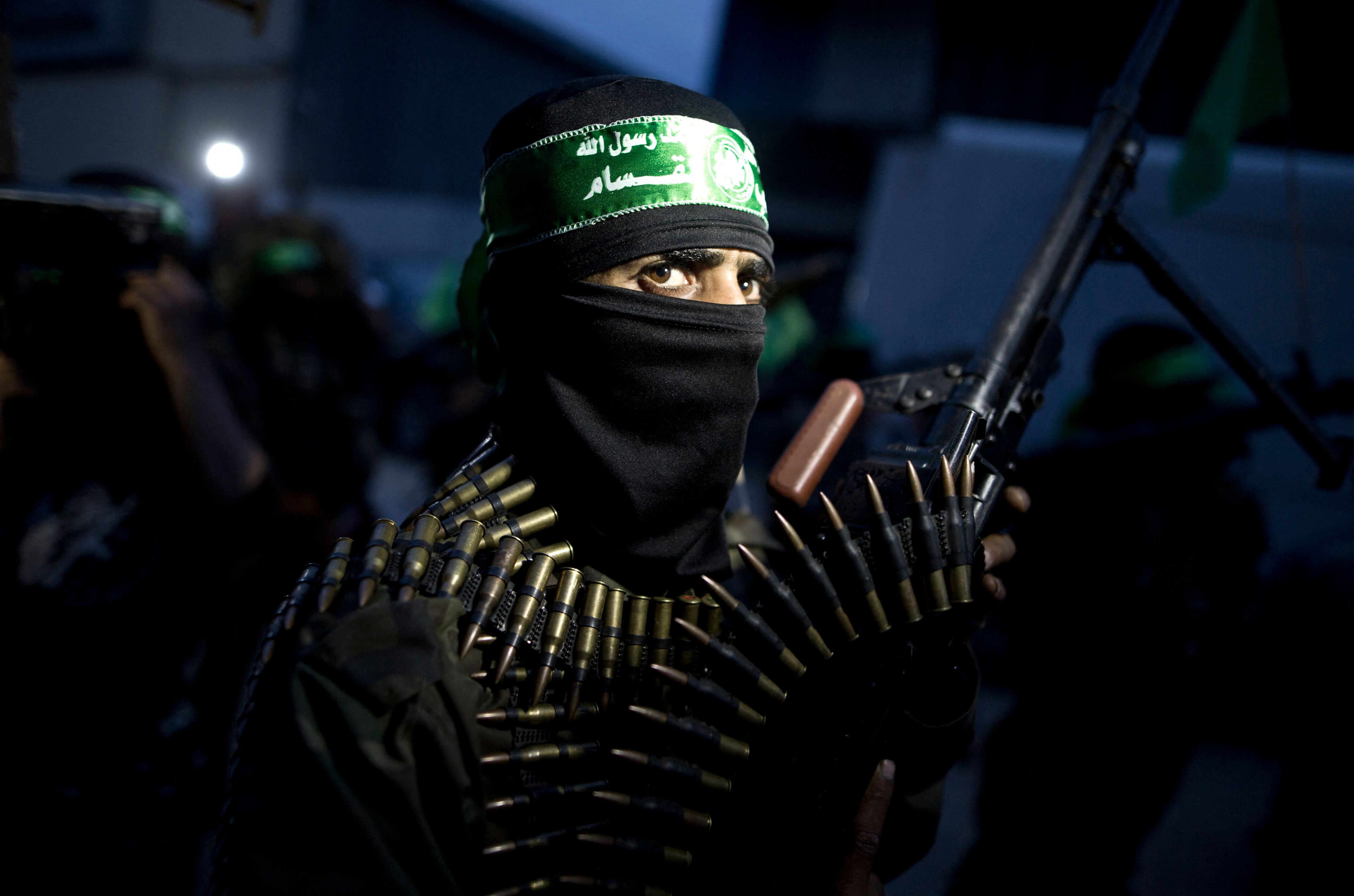 TOPSHOT - A member of the Ezzedine al-Qassam Brigades, the military wing of the Palestinian Islamist movement Hamas holds his weapon during a rally on March 23, 2016 in Gaza city to mark the 12th anniversary of the assassination of Hamas spiritual leader Sheikh Ahmed Yassine. (Photo by MAHMUD HAMS / AFP) (Photo by MAHMUD HAMS/AFP via Getty Images)