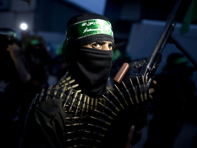 TOPSHOT - A member of the Ezzedine al-Qassam Brigades, the military wing of the Palestinian Islamist movement Hamas holds his weapon during a rally on March 23, 2016 in Gaza city to mark the 12th anniversary of the assassination of Hamas spiritual leader Sheikh Ahmed Yassine. (Photo by MAHMUD HAMS / AFP) (Photo by MAHMUD HAMS/AFP via Getty Images)