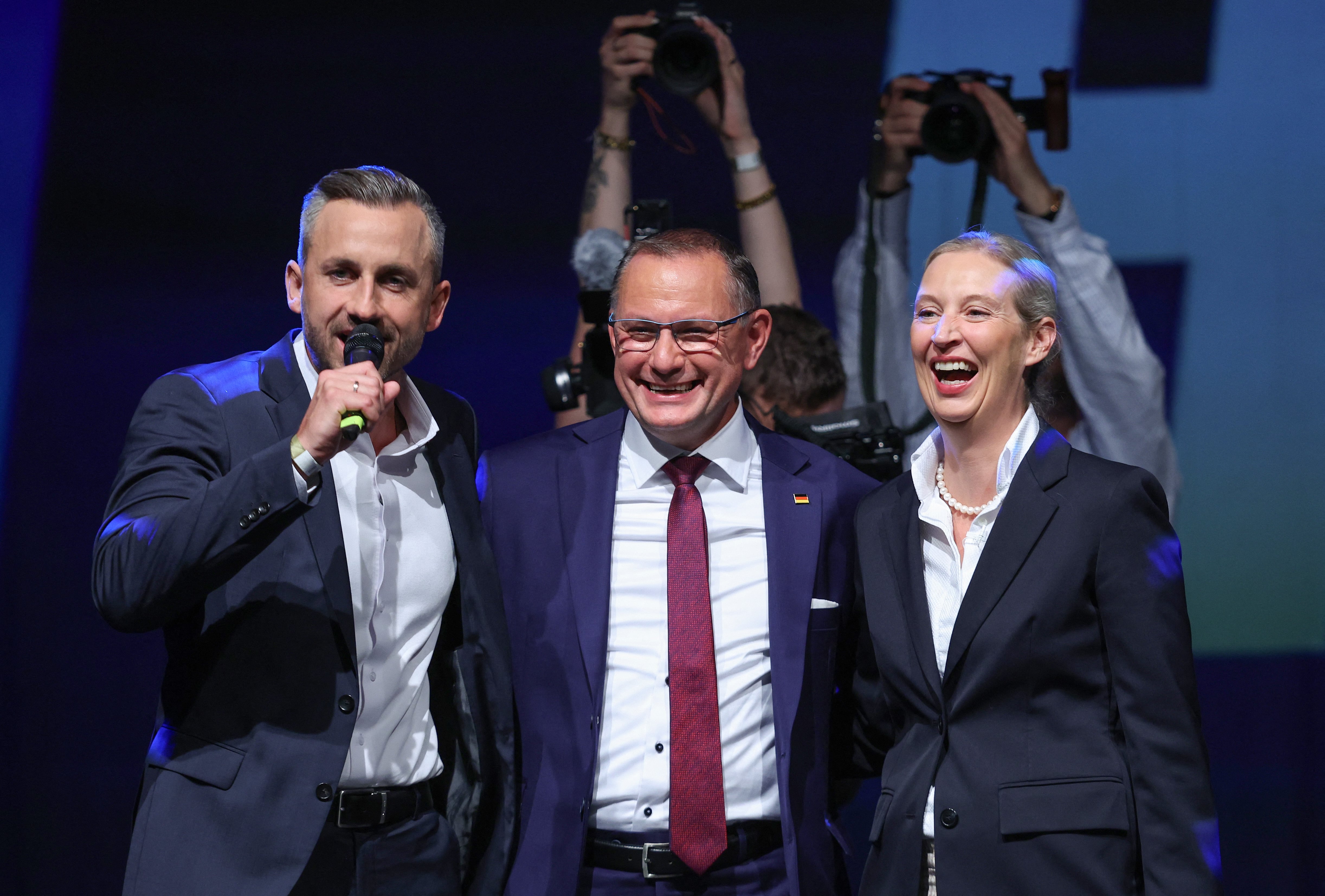 Ulrich Siegmund (L), far-right Alternative for Germany (AfD)'s main candidate in the Saxony-Anhalt state election, addresses supporters next AfD co-leaders Tino Chrupalla and Alice Weidel (R) at the AfD's election party following Saxony-Anhalt's state elections in Magdeburg, eastern Germany on September 6, 2026. Germany's far-right AfD won a landslide victory in a key regional election on September 6 in the ex-communist east, according to exit polls, but it remain unclear whether it can win an absolute majority to govern. (Photo by Ronny HARTMANN / AFP)