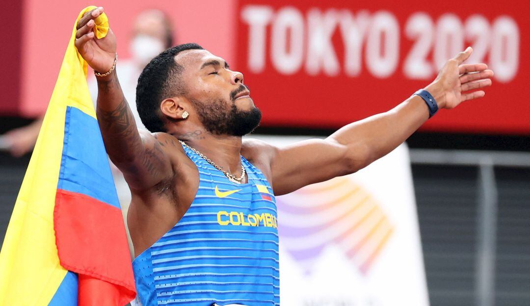 Anthony Zambrano festeja con la bandera de Colombia tras ganar la medalla de plata en los 400 metros planos.