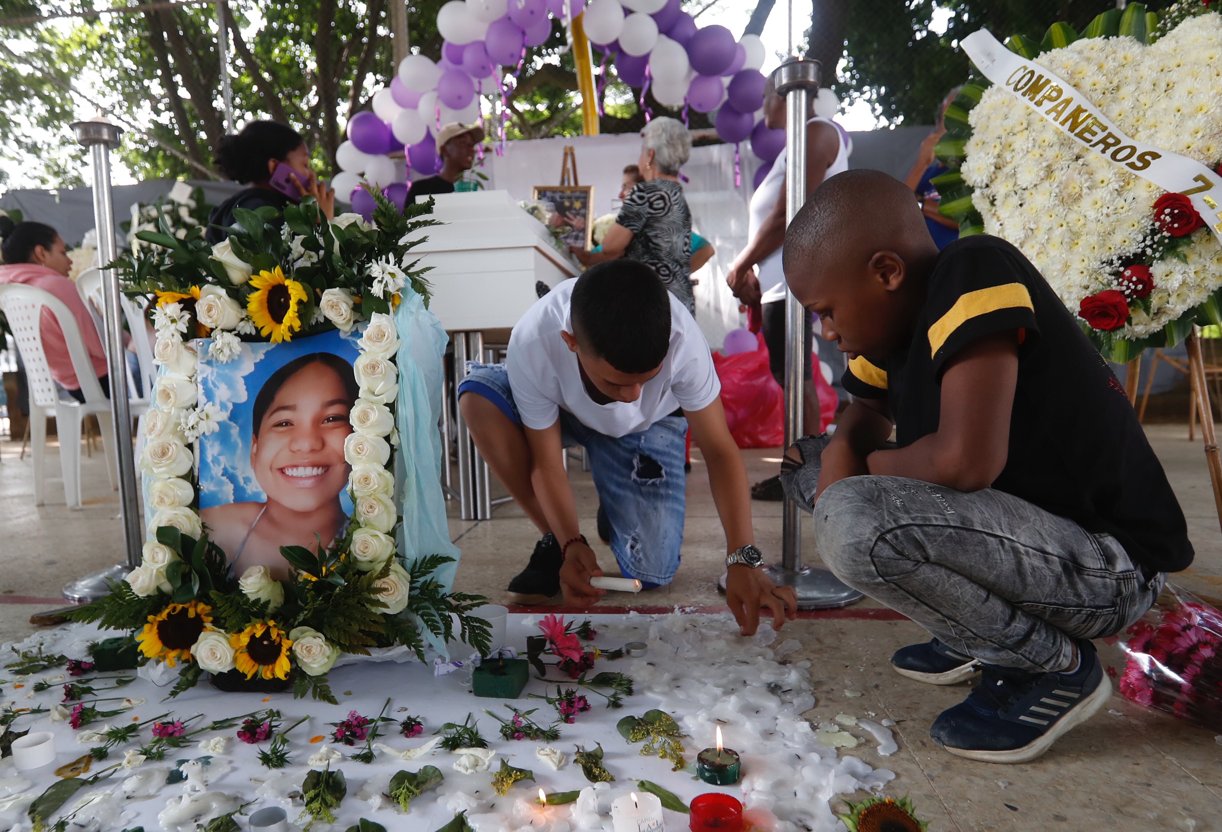 AME3818. CALI (COLOMBIA), 11/12/2023.- Familiares y amigos asisten hoy al velorio de Michelle Dayana González, una menor de 14 años que fue asesinada y descuartizada en un centro automotor, en Cali (Colombia). Una docena de velas, una veintena de ramos de flores y pancartas exigiendo justicia rodean el féretro de Michelle Dayana González, la niña de 14 años que fue asesinada y desmembrada en la noche del pasado 7 de diciembre en un feminicidio cometido en el barrio San Judas de la ciudad de Cali, en el suroeste de Colombia. Su velorio se realiza en el polideportivo del barrio que la vio crecer y en el que también estaba ubicado el taller donde un hombre, el sospechoso del crimen, la llevó con engaños para cometer el asesinato. El lugar ahora está decorado con grafitis que dicen las niñas no se tocan, no se matan. EFE/Ernesto Guzmán