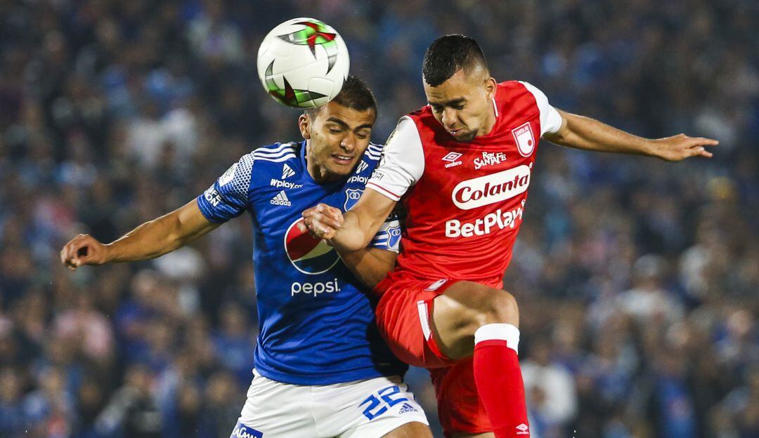 Daniel Giraldo disputa una pelota aérea en un clásico con Jhon Duque.