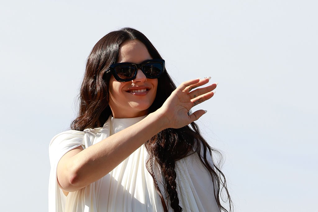 PARIS, FRANCE - OCTOBER 01: Rosalía is seen wearing white chiffon high-neck mini dress, black bow shoes and Dior black sunglasses outside Dior during the Womenswear Spring Summer 2026 as part of Paris Fashion Week on October 01, 2025 in Paris, France. (Photo by Hanna Lassen/Getty Images)
