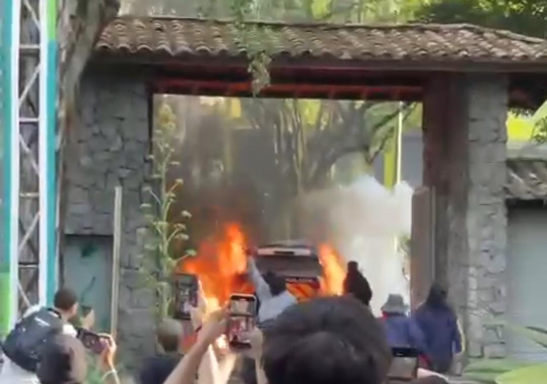 Foto: Momento en el que los encapuchados le prenden fuego a la camioneta de la policía en la UdeA. Caracol Radio.