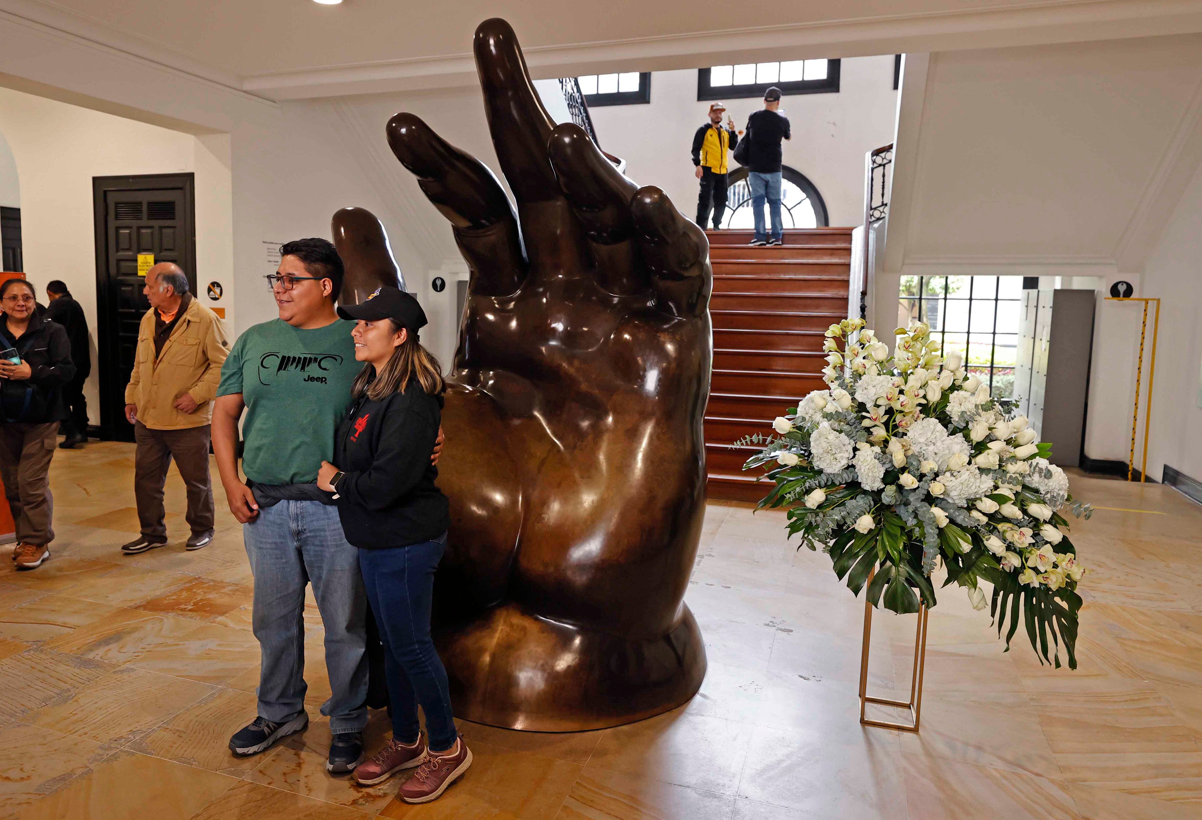 AME9885. BOGOTÁ (COLOMBIA), 15/09/2023.- Una pareja posa junto a la escultura La Mano de Fernando Botero hoy, en el Museo Fernando Botero en Bogotá (Colombia). El maestro colombiano Fernando Botero, fallecido este viernes a los 91 años, fue el artista de las figuras voluminosas, "no gordas", como solía aclarar, una obra que lo convirtió en artista universal y que hoy está repartida en forma de pinturas y esculturas en museos y plazas de todo el mundo. EFE/ Mauricio Dueñas Castañeda