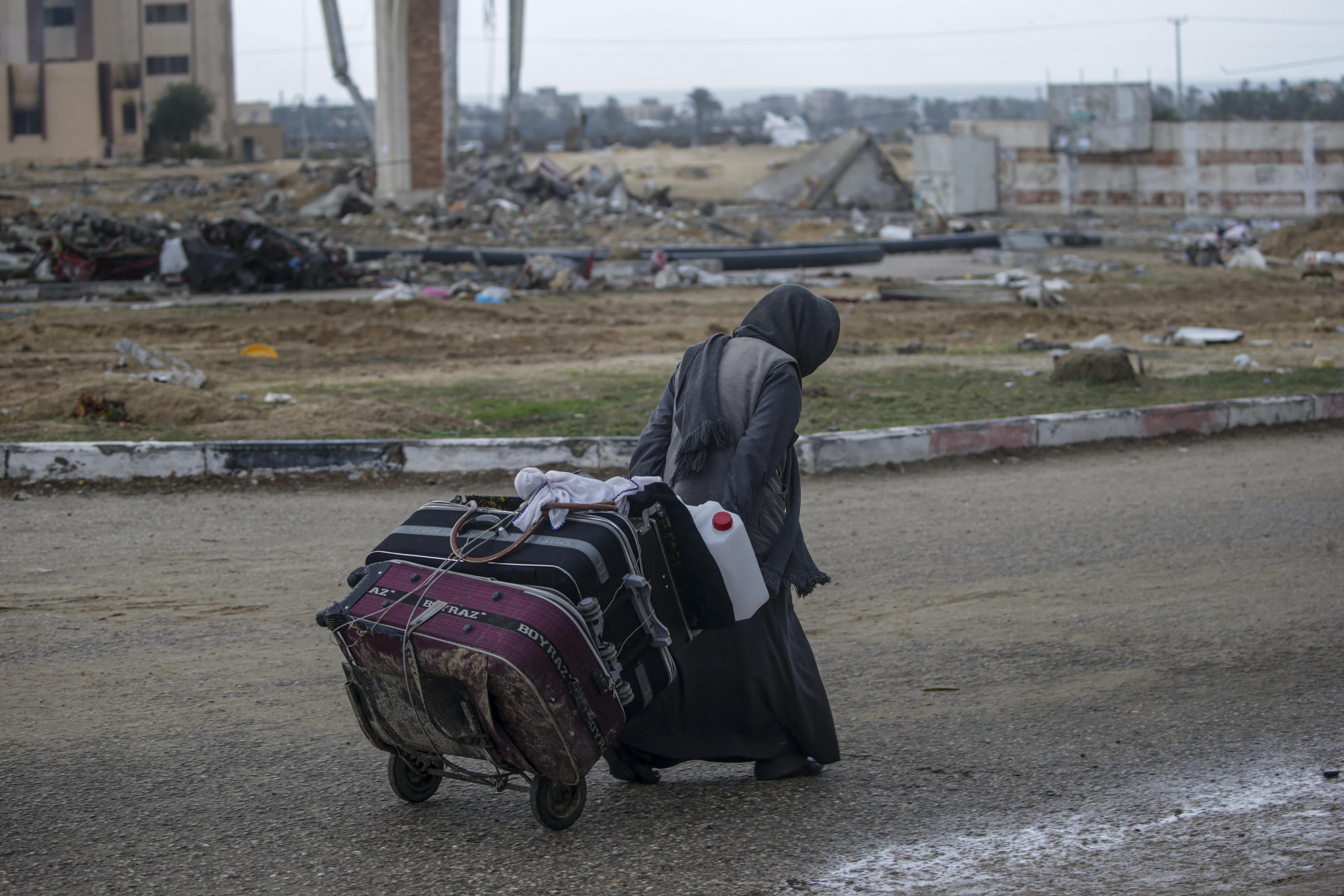 -FOTODELDÍA- Khan Younis (---), 27/01/2024.-Los palestinos desplazados pasan junto a casas destruidas después de que el ejército israelí dijera a los residentes del campamento de Khan Yunis que abandonaran sus hogares y se dirigieran hacia los campamentos de Rafah, cerca de la frontera con Egipto, en el sur de la Franja de Gaza, el 27 de enero de 2024. EFE/EPA/MOHAMMED SABER
