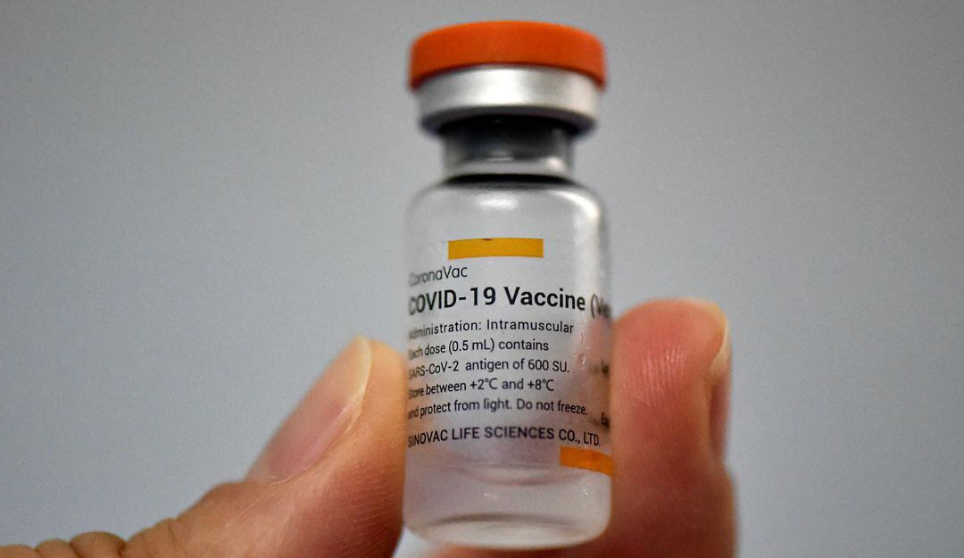 Una persona sostiene un vial de la vacuna Sinovac contra COVID-19