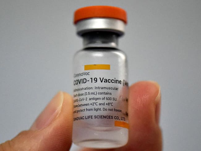 Una persona sostiene un vial de la vacuna Sinovac contra COVID-19