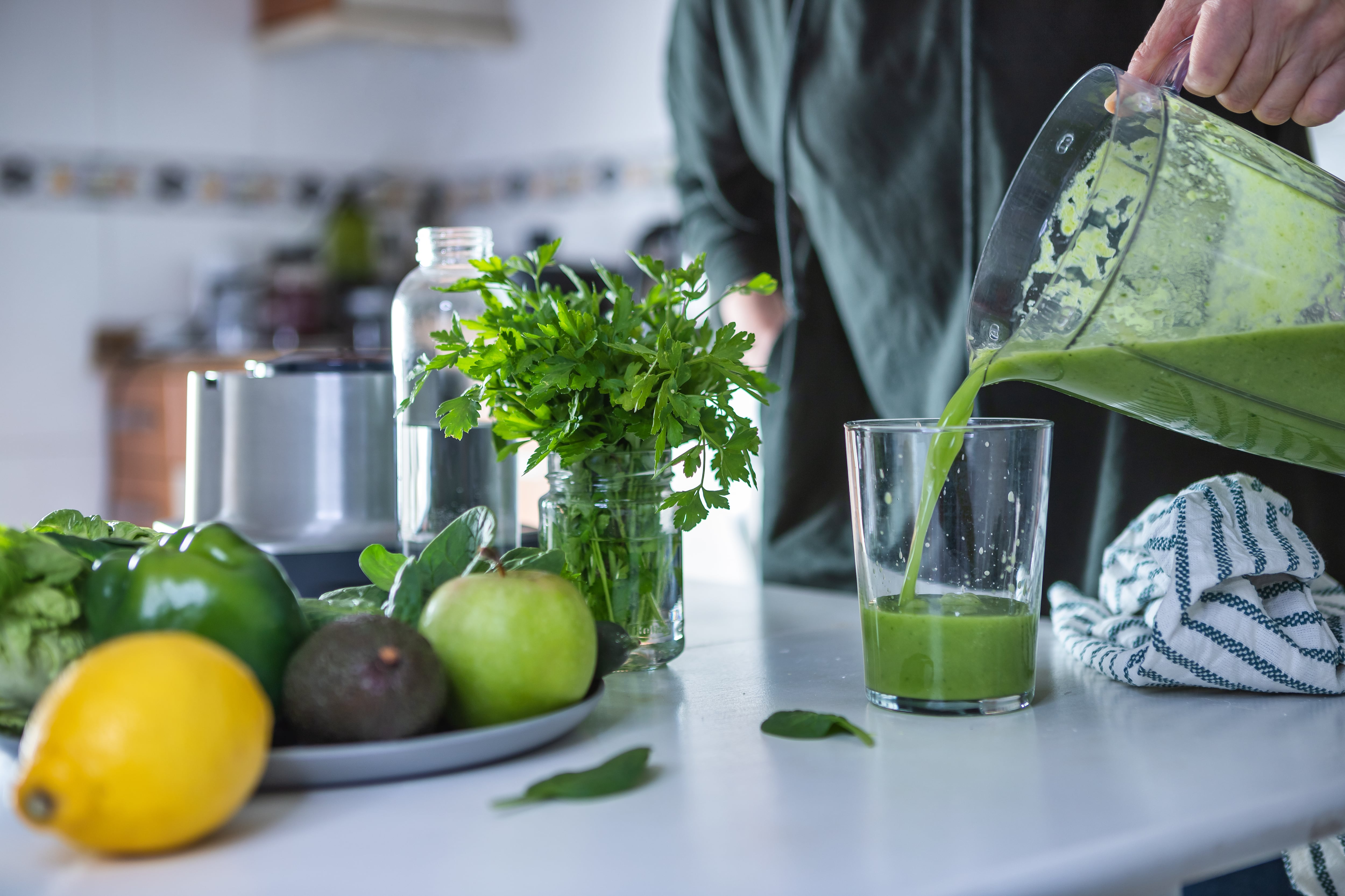 Persona sirviendo un batido verde (Foto vía Getty Images)