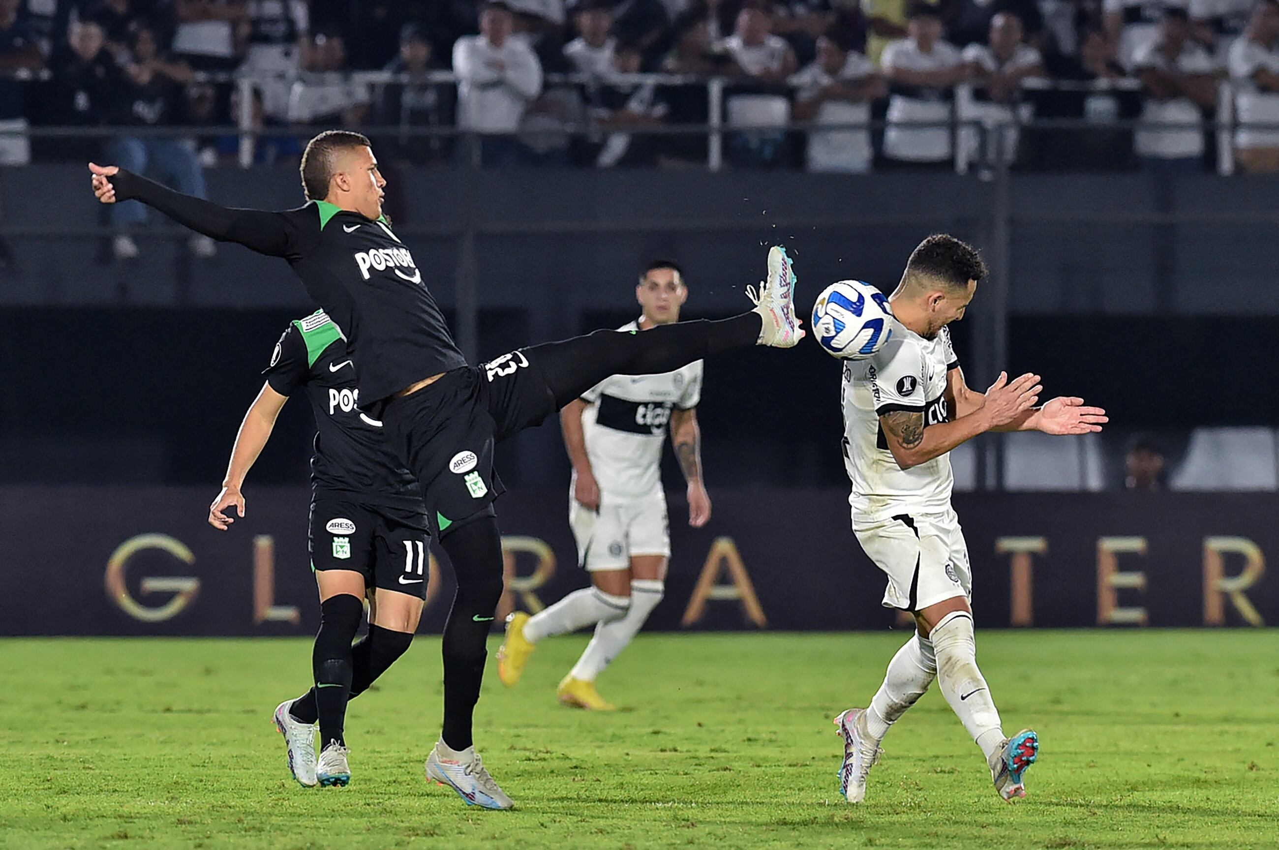 Atletico Nacional's midfielder Nelson Deossa (L) fights for the ball with Olimpia's forward Fernando Cardozo during the Copa Libertadores group stage second leg football match between Paraguay's Olimpia and Colombia's Atletico Nacional at the Defensores del Chaco stadium in Asuncion on June 8, 2023. (Photo by NORBERTO DUARTE / AFP) (Photo by NORBERTO DUARTE/AFP via Getty Images)