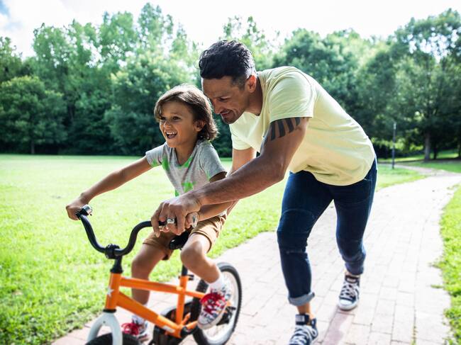 Father teaching son to ride a bicycle