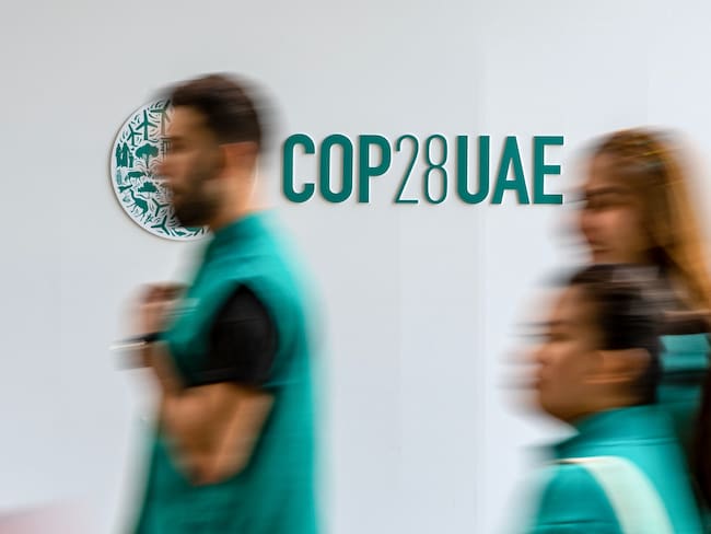 Dubai (United Arab Emirates), 11/12/2023.- Participants walk past the COP28 logo at Expo Dubai, the venue of the 2023 United Nations Climate Change Conference (COP28), in Dubai, United Arab Emirates, 11 December 2023. COP28 runs from 30 November to 12 December, and is expected to host one of the largest number of participants in the annual global climate conference as over 70,000 estimated attendees, including the member states of the UN Framework Convention on Climate Change (UNFCCC), business leaders, young people, climate scientists, Indigenous Peoples and other relevant stakeholders will attend. (Emiratos Árabes Unidos) EFE/EPA/MARTIN DIVISEK