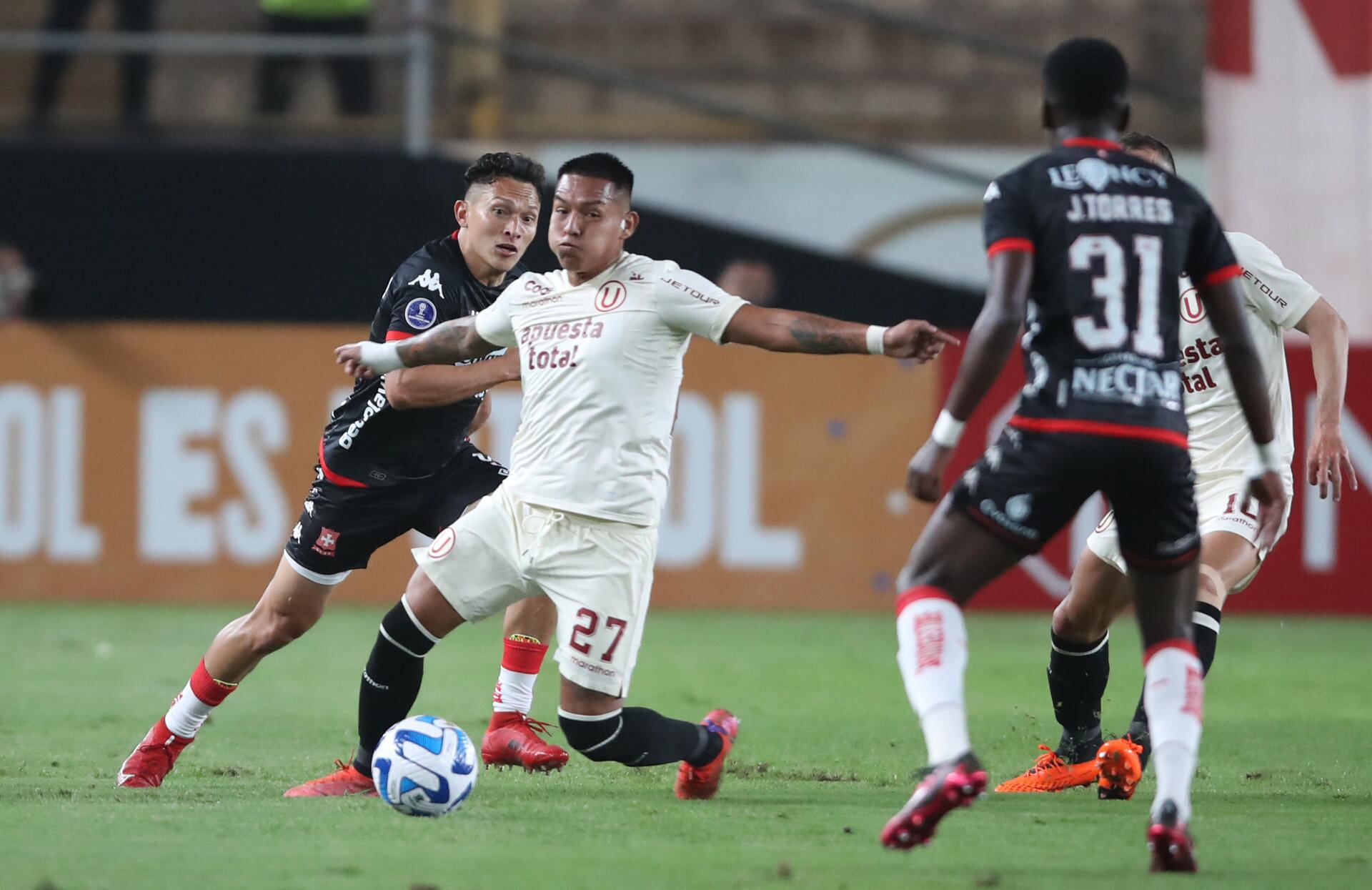 Nelson Cabanillas de Universitario disputa hoy el balón con Wilfrido de la Rosa (i) de Santa Fe, durante un partido por el Grupo G de la Copa Sudamericana en el Estadio Monumental en Lima (Perú). EFE/ Paolo Aguilar