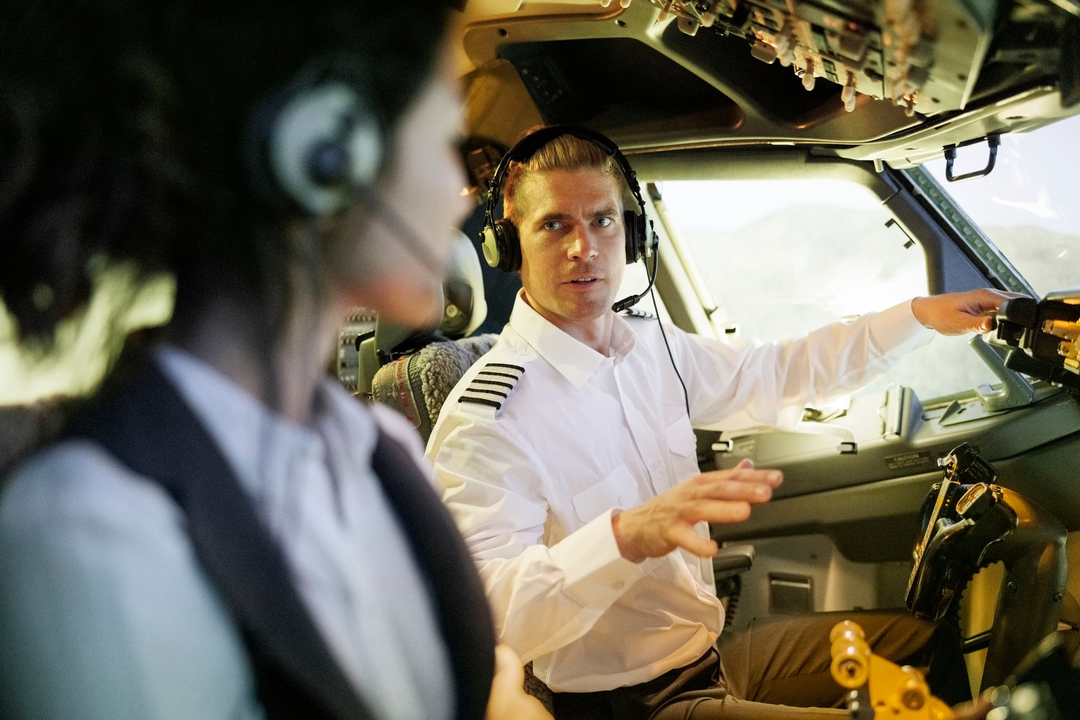 Piloto con pasante en cabina de avión, imagen de referencia // GettyImages