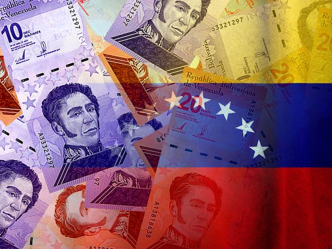 Bolívares cash bills and Venezuela flag (money, economy, finance, business, crisis, inflation)