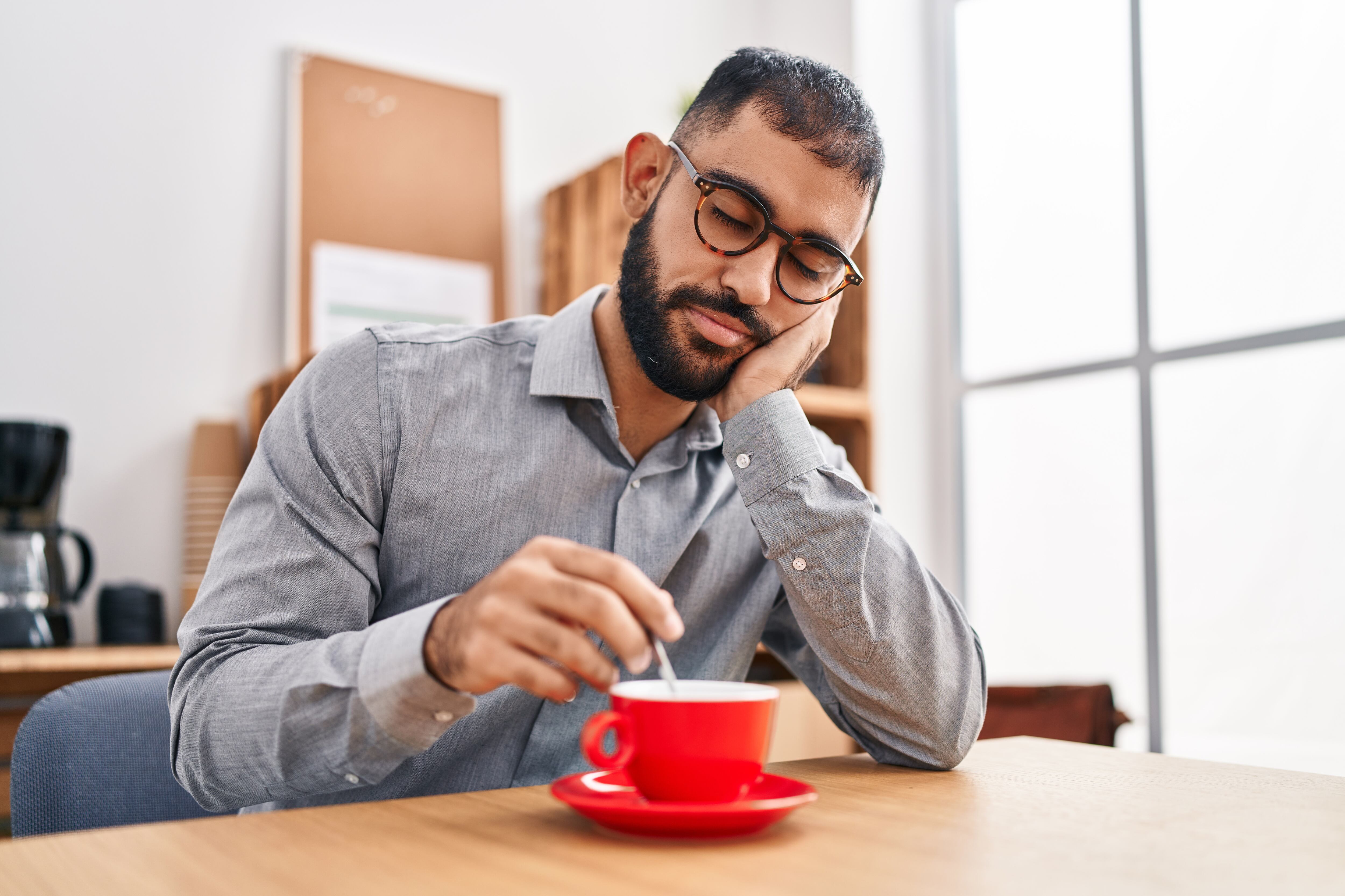 Hombre con sueño bebiendo una taza de café (Foto vía Getty Images)