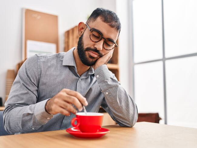 Hombre con sueño bebiendo una taza de café (Foto vía Getty Images)