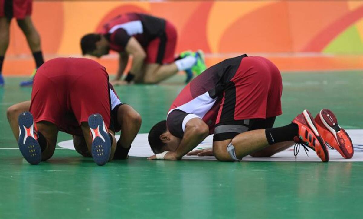 Jugadores de Egipto besan el piso luego de su victoria ante Suecia en las competencias de balonmano.
