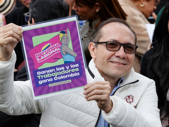 AME8527. BOGOTÁ (COLOMBIA), 25/06/2025.- El ministro del Trabajo de Colombia Antonio Sanguino sostiene un cartel que promociona la reforma laboral este miércoles, en Bogotá (Colombia). El presidente de Colombia, Gustavo Petro, firmó la reforma laboral, cinco días después de que el Congreso aprobara esta iniciativa que se convirtió en una de las mayores victorias legislativas de su Gobierno. EFE/ Mauricio Dueñas Castañeda
