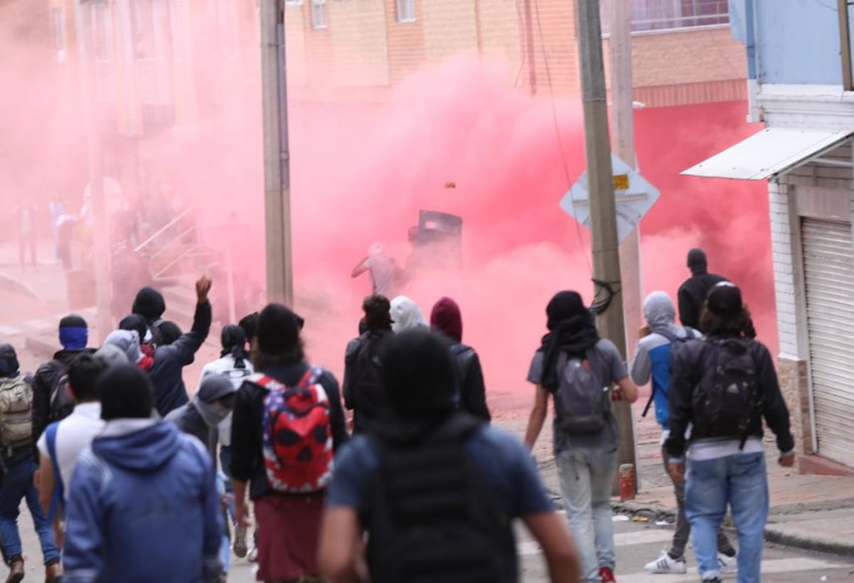 Enfrentamiento entre encapuchados y ESMAD, estos últimos están tapados por los gases lacrimógenos.