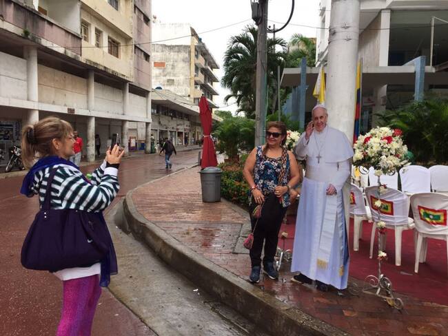 Personas se toman fotos con una imagen del papa