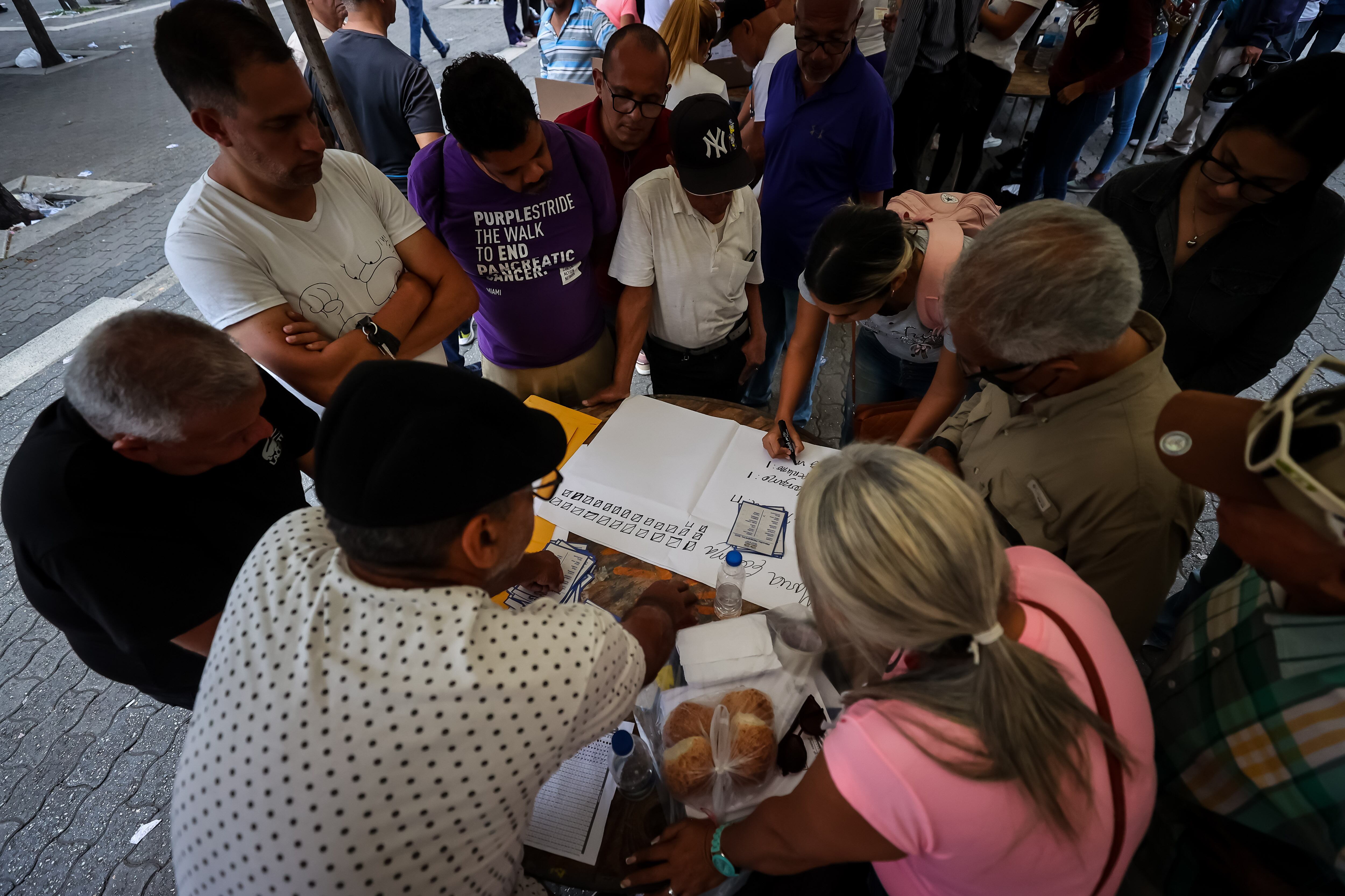 AME9666. CARACAS (VENEZUELA), 22/10/2023.- Miembros de mesas comienzan el conteo de votos durante el cierre de la jornada electoral de las primarias de la oposición, hoy, en Caracas (Venezuela). Comienzan los conteos tras el cierre de las mesas de votación para las elecciones internas de la oposición en Venezuela para escoger al candidato del antichavismo para las elecciones presidenciales del segundo semestre de 2024. A las internas de la oposición concurren 10 candidatos, de los 13 inscritos inicialmente. EFE/ Miguel Gutiérrez